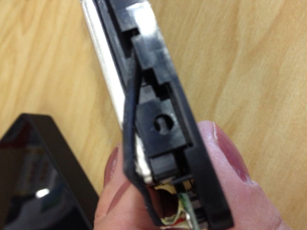 There will be a band on one side of the case to work around, so gently pull it up and out of the way to insert the screw.