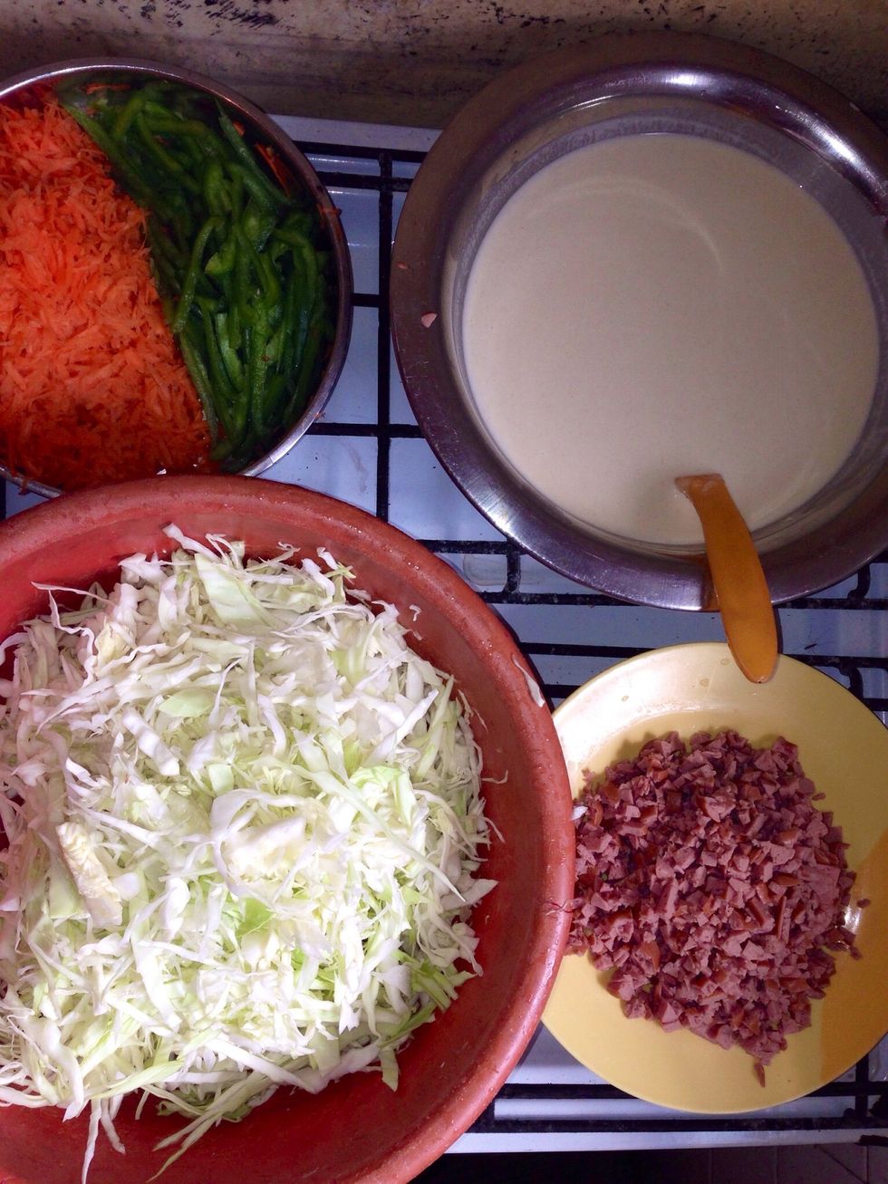 These are chopped vegetables and hot dog. The batter for the wrappers is in d bowl consisting flour, water and salt. It is runny but thick enough to slightly coat a spoon...