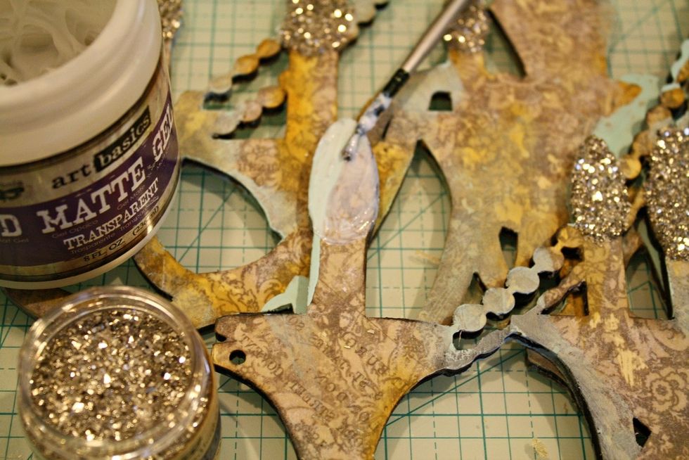 These chandeliers have a "flame/candle" to them which I LOVE! I used Sterling Glass Glitter to accentuate & highlight them! First add 3D matte gel to each candle tip for dimension.