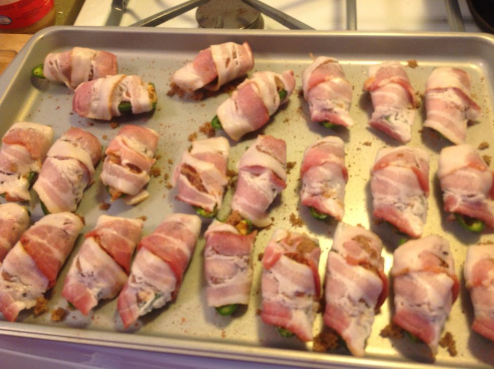 They say that anything wrapped in bacon tastes good. So true. Cut bacon slices in half and wrap around your peppers, creating neat little bundles.