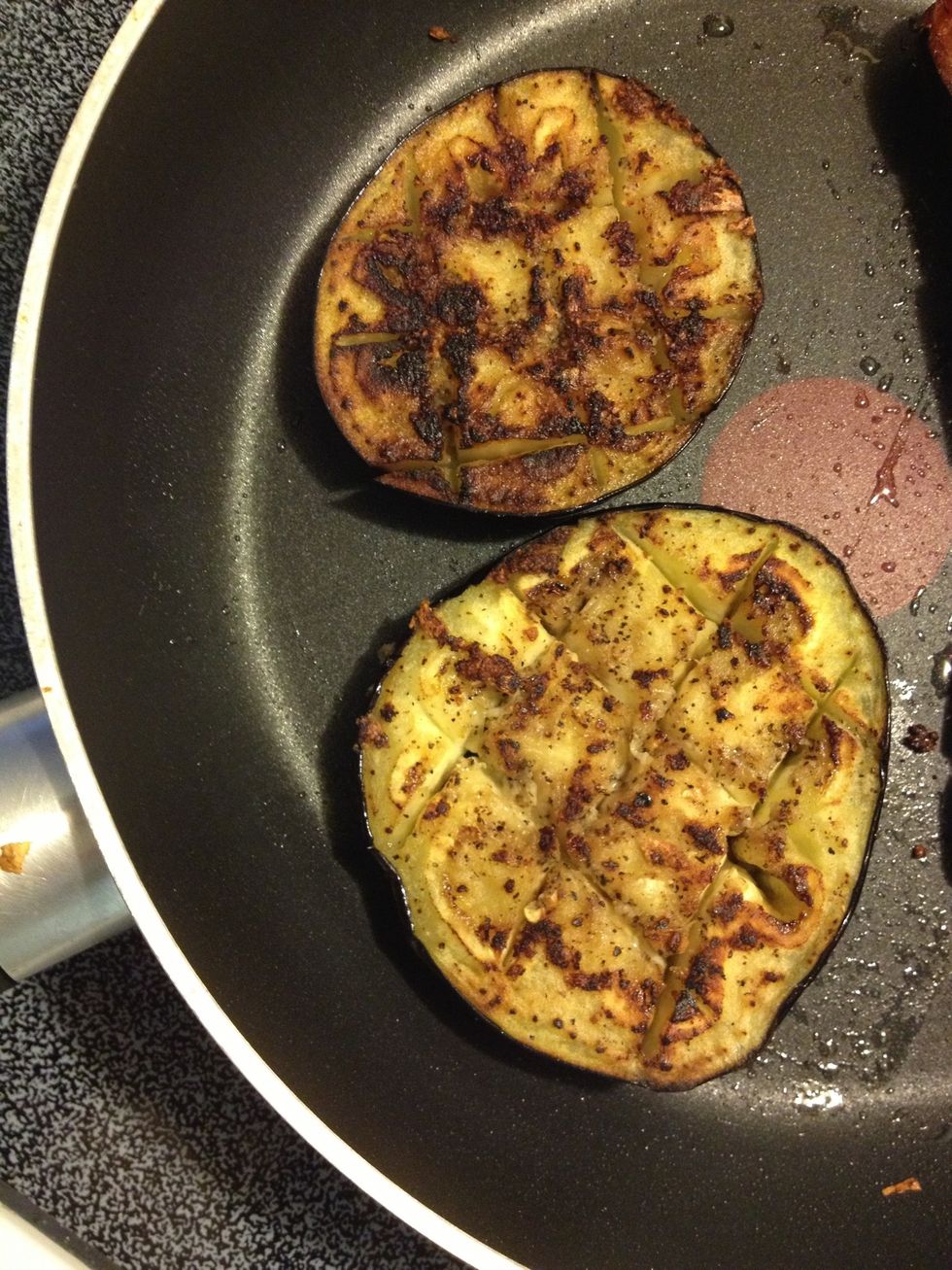 They should get slightly burned on the surface. Eggplants absorb oil so you will need to add a tsp oil whenever your pan goes dry.