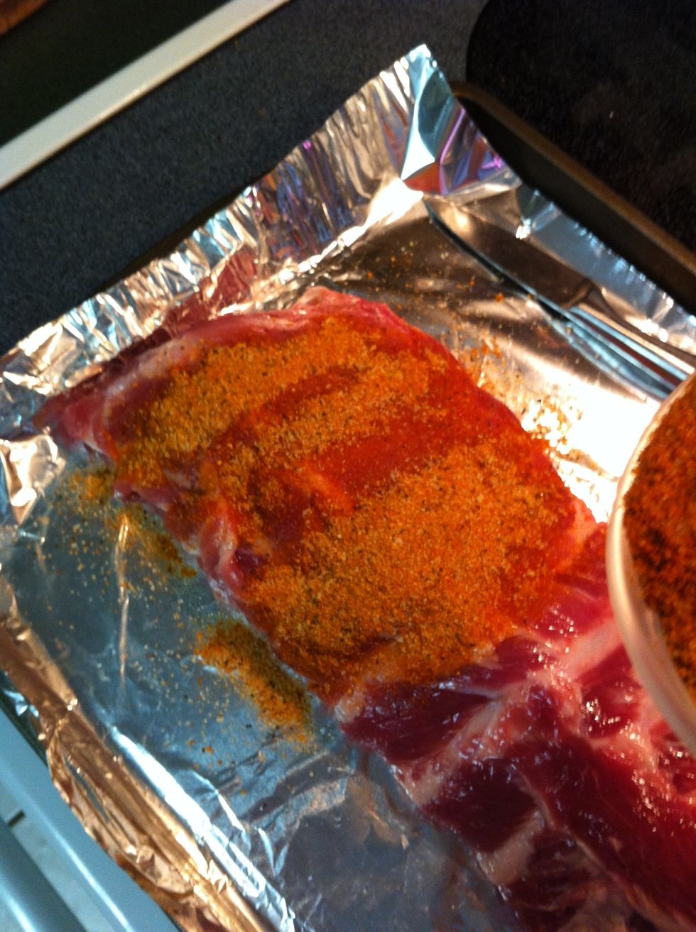 Thinly coat ribs with olive oil or mustard, (you won't taste it) then apply rub. Generously or conservatively, it's up to you. A lot makes for good "bark."