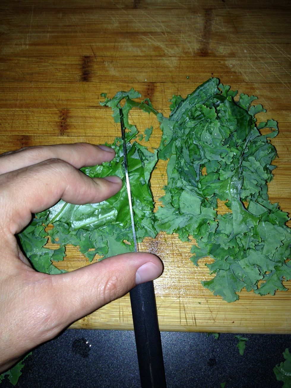 Thinly slice the kale and repeat with remaining leaves. Add sliced leaves to a salad bowl.