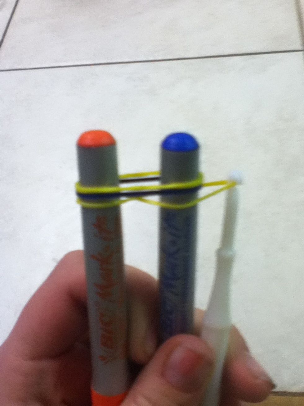 Third, take the very bottom ruberband and pull it over the sharpie