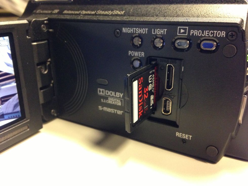 This camera uses an SD card for recording. Slide the SD card slot on the side of the camera to verify the SD card is inserted correctly.