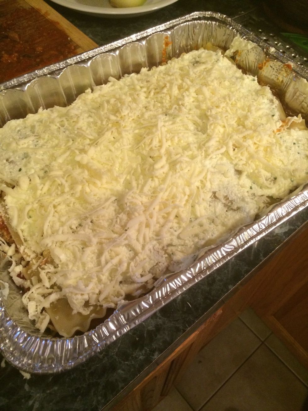 This fifth layer is just like the first layer, ricotta, mozzarella and grated cheese. When done add 3 more noodles over this