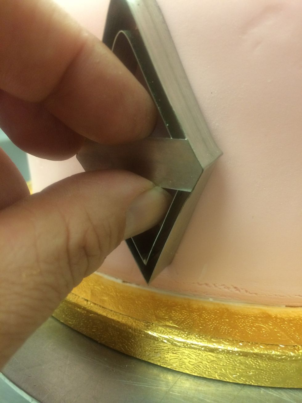 This is a a fondant quilting die. It gets pressed into the side of the cake leaving an imprint into the fondant.