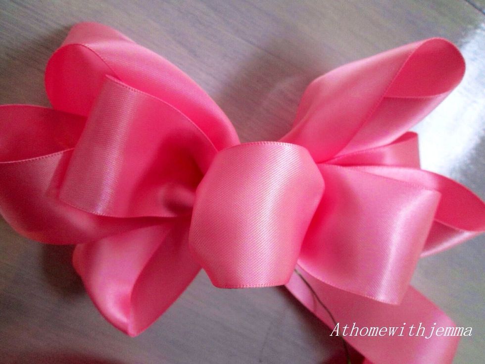 This is a five Loop bow with a number #3 pink ribbon. The length of the ribbon = your arm spanned. (put a wire through the center of the bow and put a wooden pick into the vase to secure the bow).