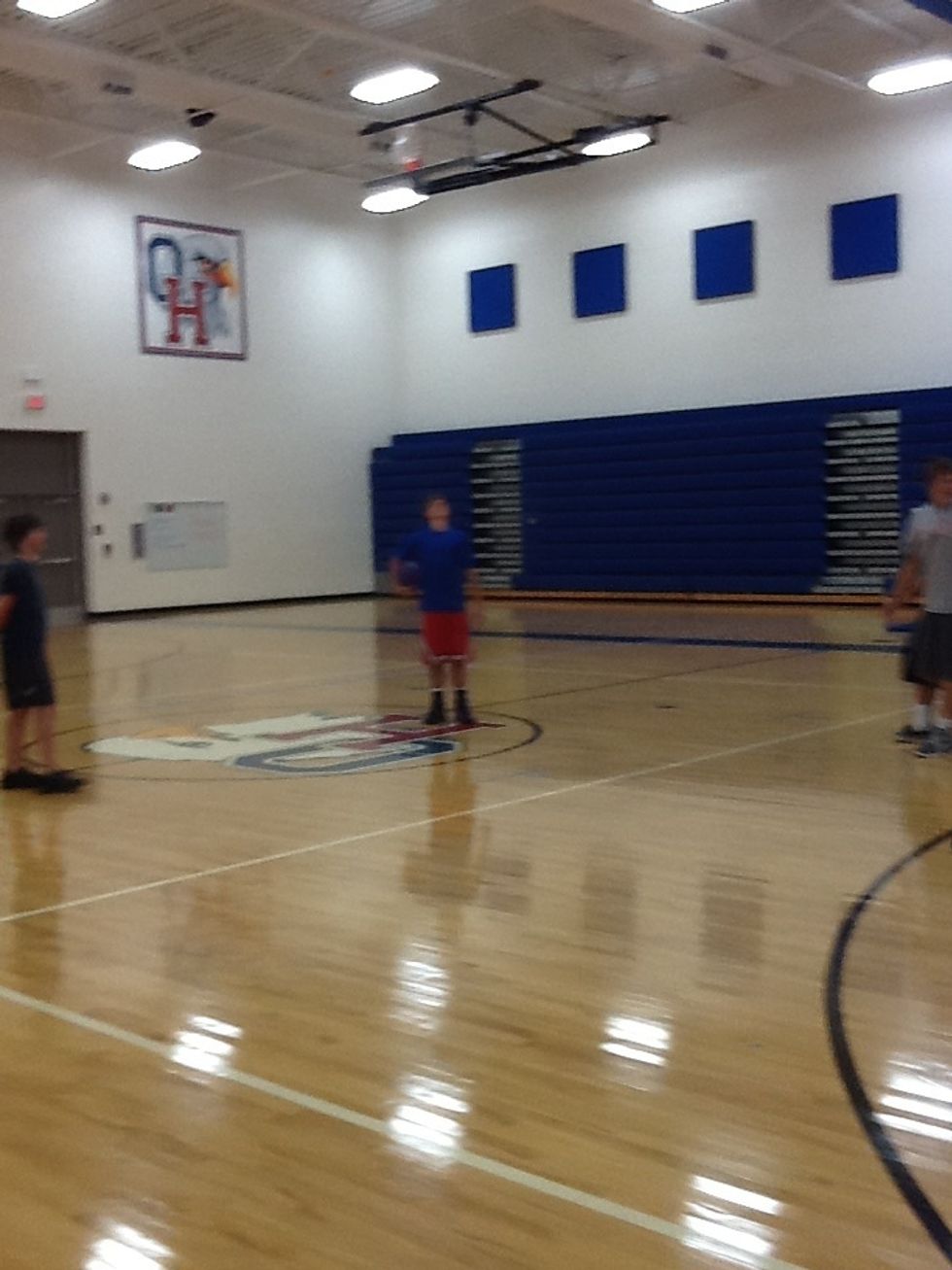 This is a kid playing kick ball in gym.