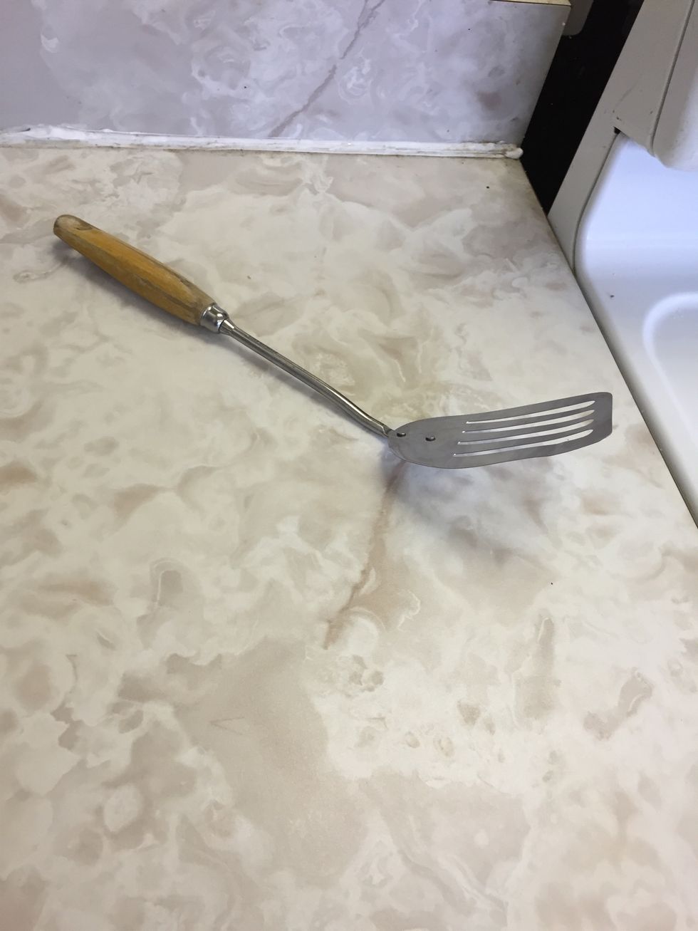 This is a metal spatula. You use it when you are flipping food. I can use a spatula when I make hamburgers.