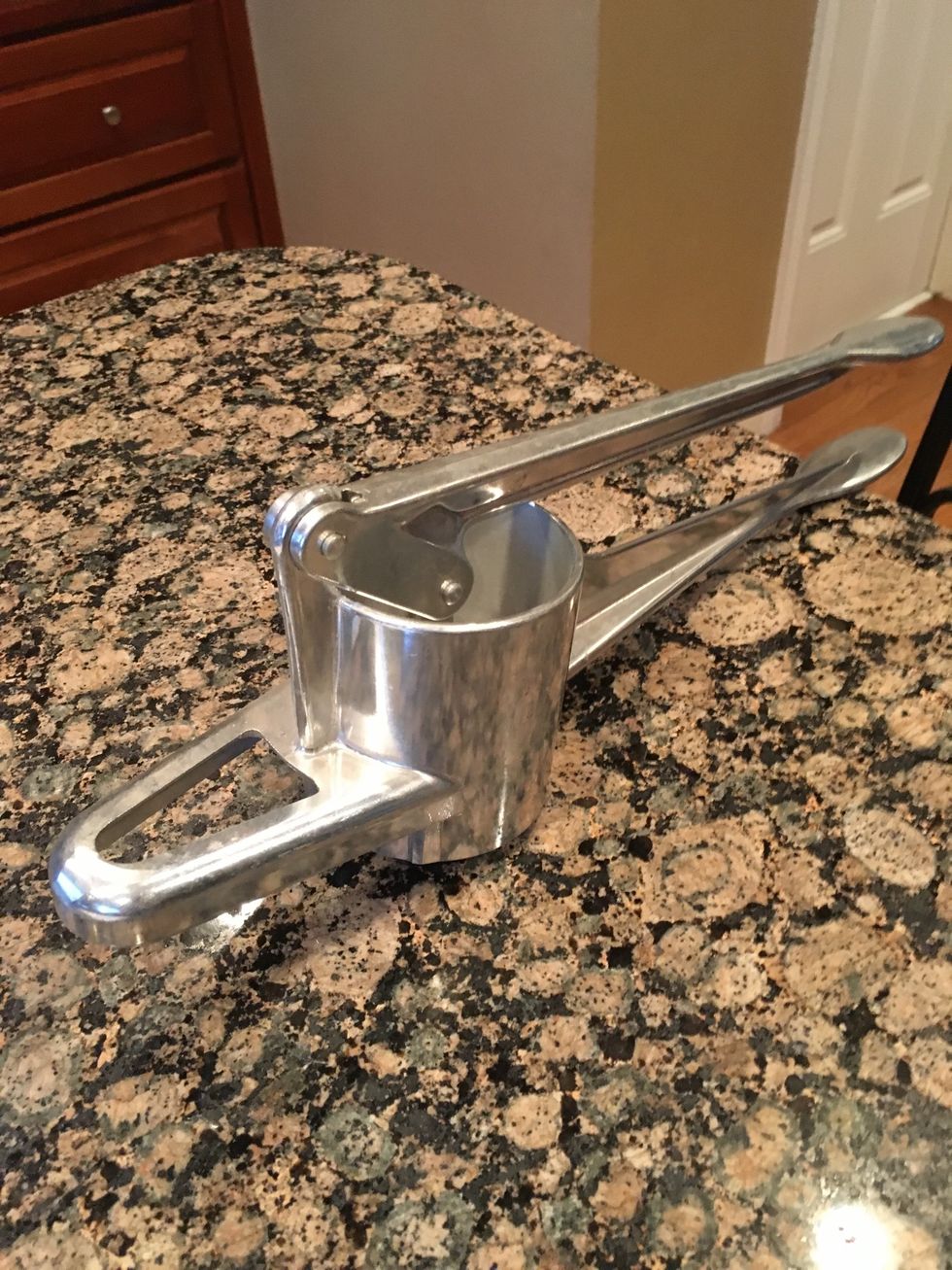 This is a ricer it is used for processing potatoes or other foods by forcing it through a sheet of small holes