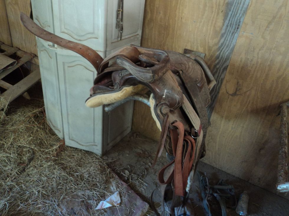 This is a western saddle. To not hit the horse, or yourself, put the stirrup on the horn of the saddle.