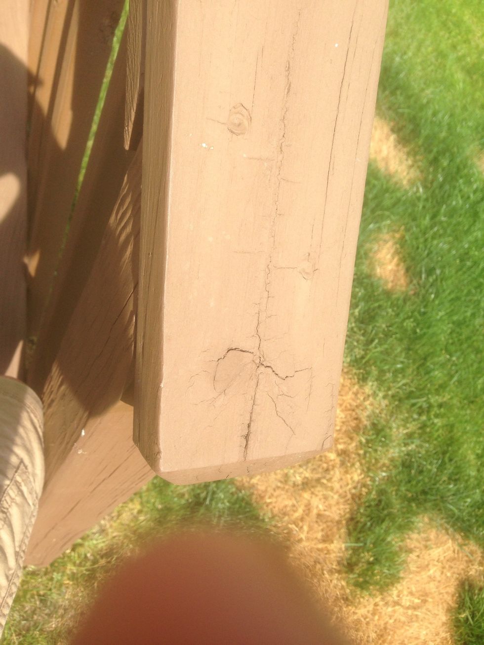 This is an example of weathering because water and wind wore away at the wood and created a crack in the wood.