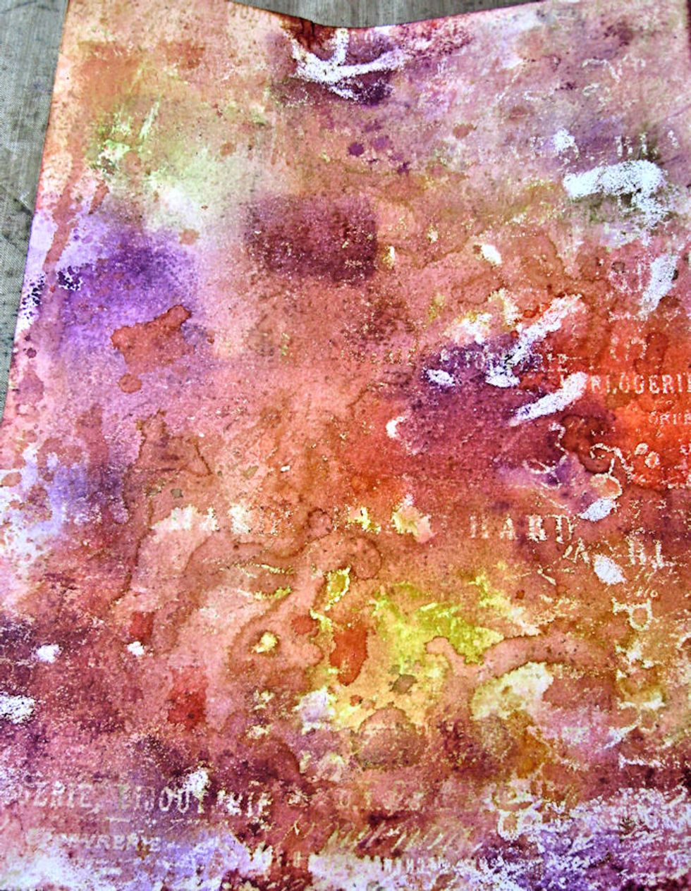 This is how it looks after adding more ink.  See how the stamped/embossed layer resists the ink?  Now, spritz or flick water droplets onto the inked surface to blend in the purple ink you just added.