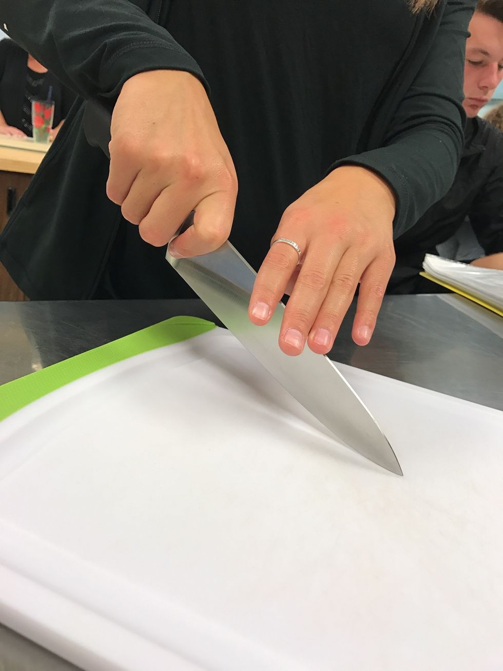 This is how you hold a knife, pinched on both sides. tips: the tip of the knife should hit the board first, move the blade in a forward-backward motion, use other hand to steady food.