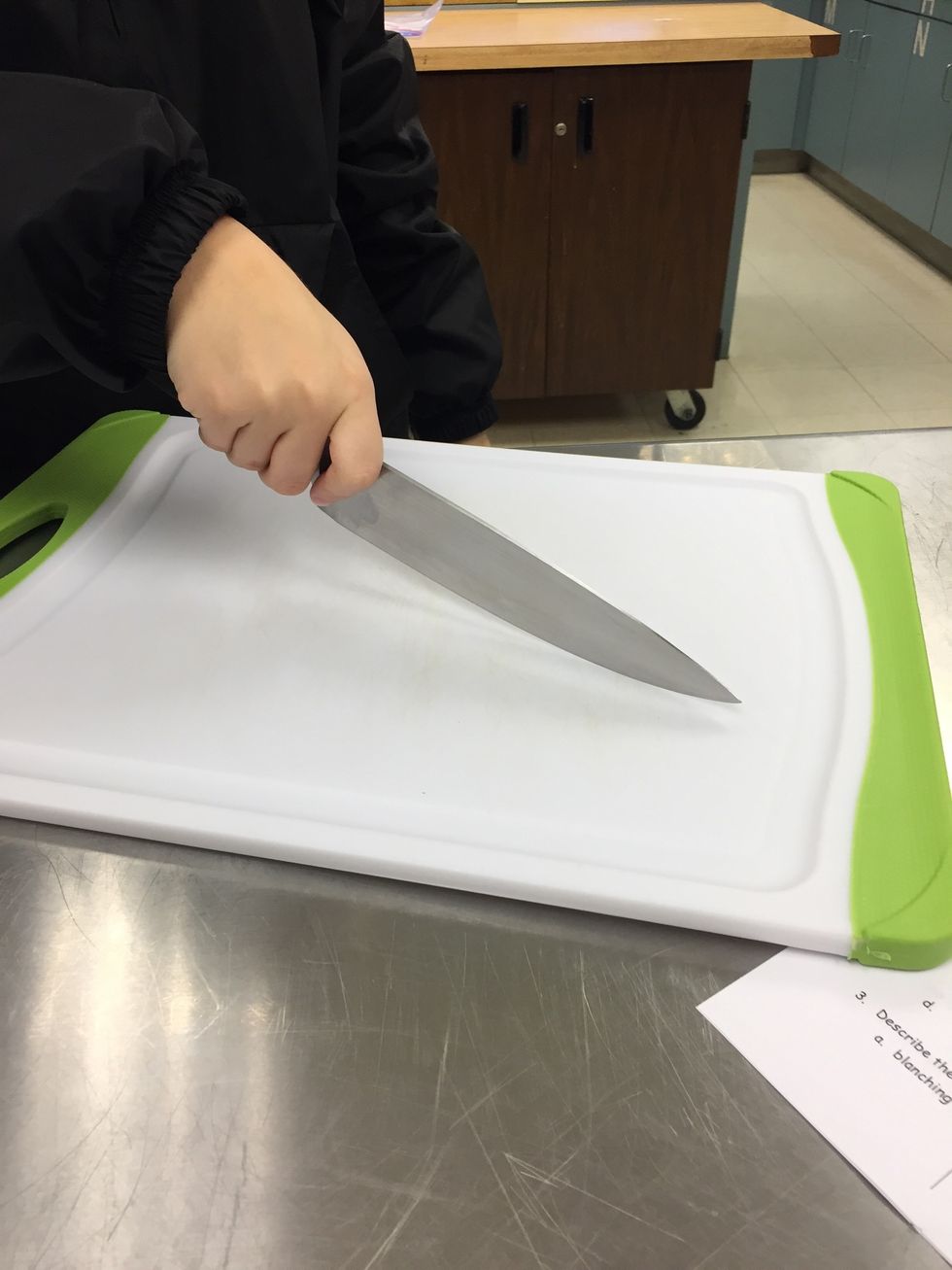 This is how you properly hold a knife. You can see her two fingers on either side of the knife and her other fingers wrapped around the handle.