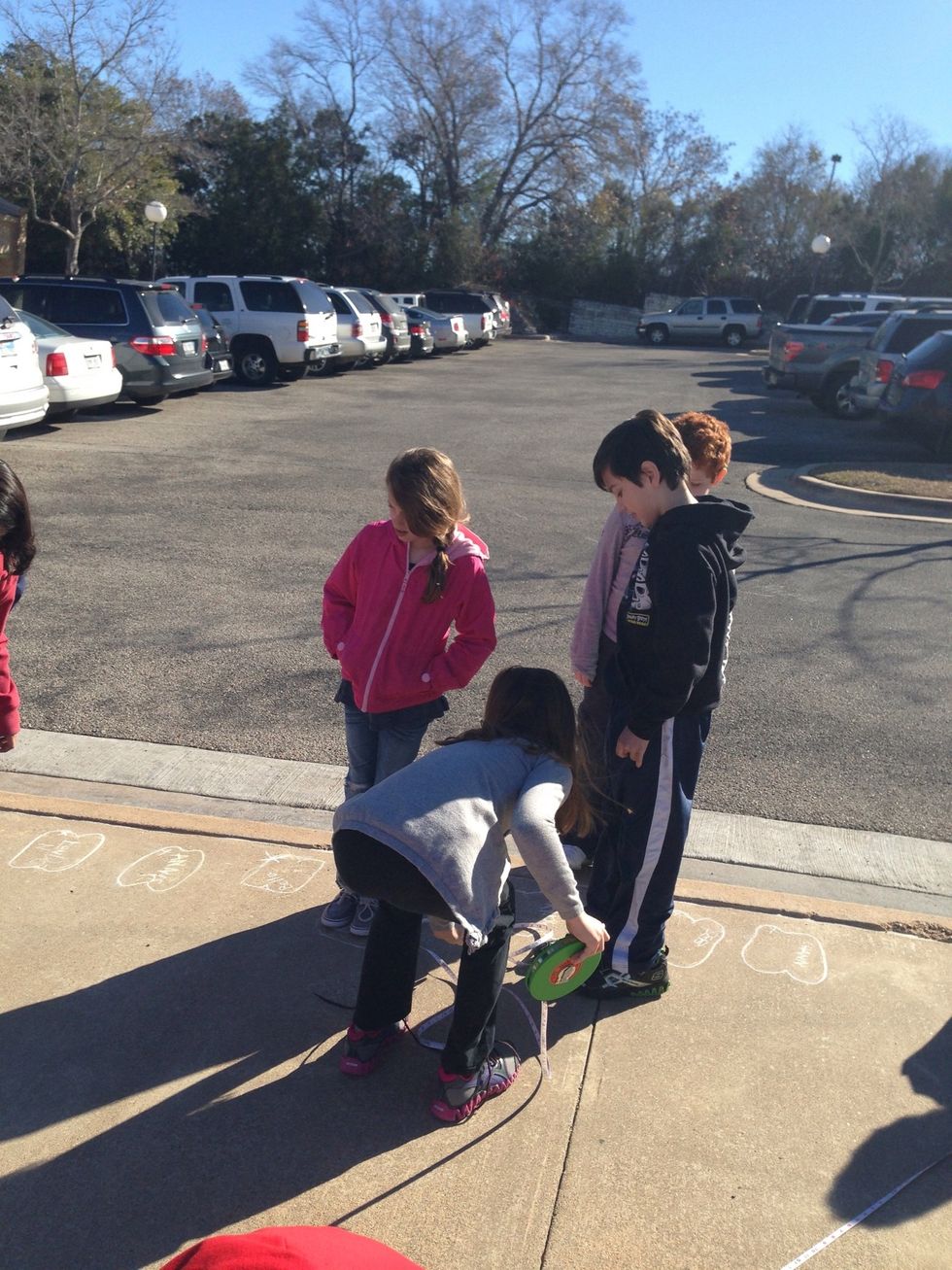 This is me doing my shadow, we stand somewhere and we outline our feet, then we stay there while another person in our group marks the end of our shadow then we measure from the feet to the mark.