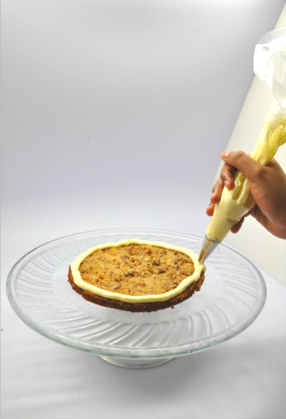 This is optional but I do think this step makes things neater. Using a plain round tip, just fill the piping bag with a little icing and ice around the cake.