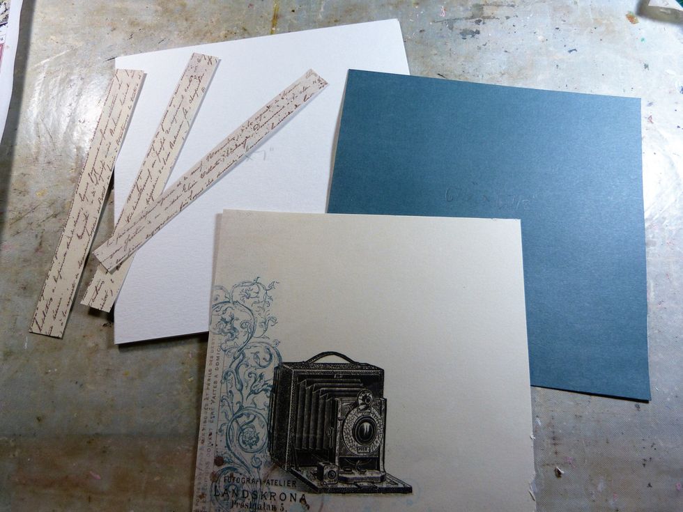 This is the card you will need; a white 7x7 card, blue Pion paper 6 7/8"  6 7/8", the camera Pion Paper 6 5/8" x 6 5/8". Three strips script Pion paper for die cutting.