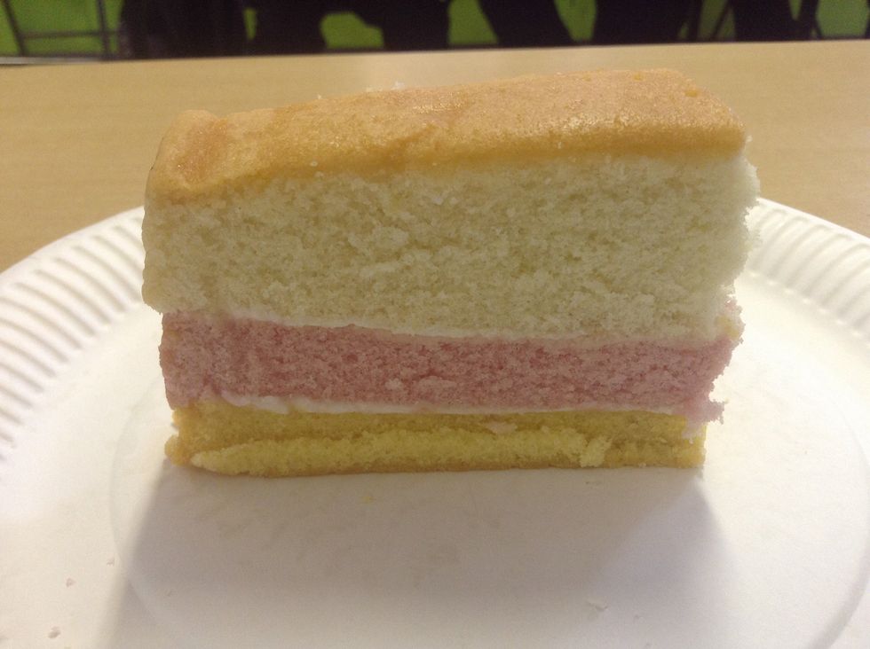 This is the cliff. The white layers of cream represent the high and low tides. The erosion happens in the pink slice, between these tide zones