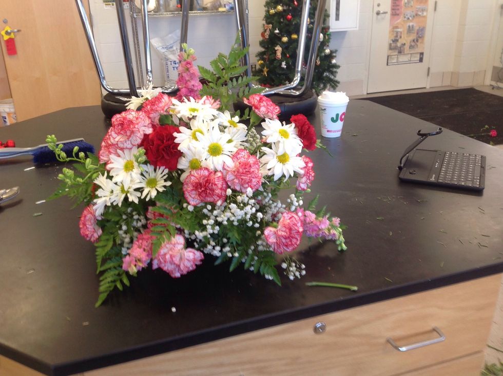 This is the finished triangle arrangement. Have at most three colors between carnations, mums, and fillers. The goal of this arrangement is to achieve proportion and have it look like a triangle.