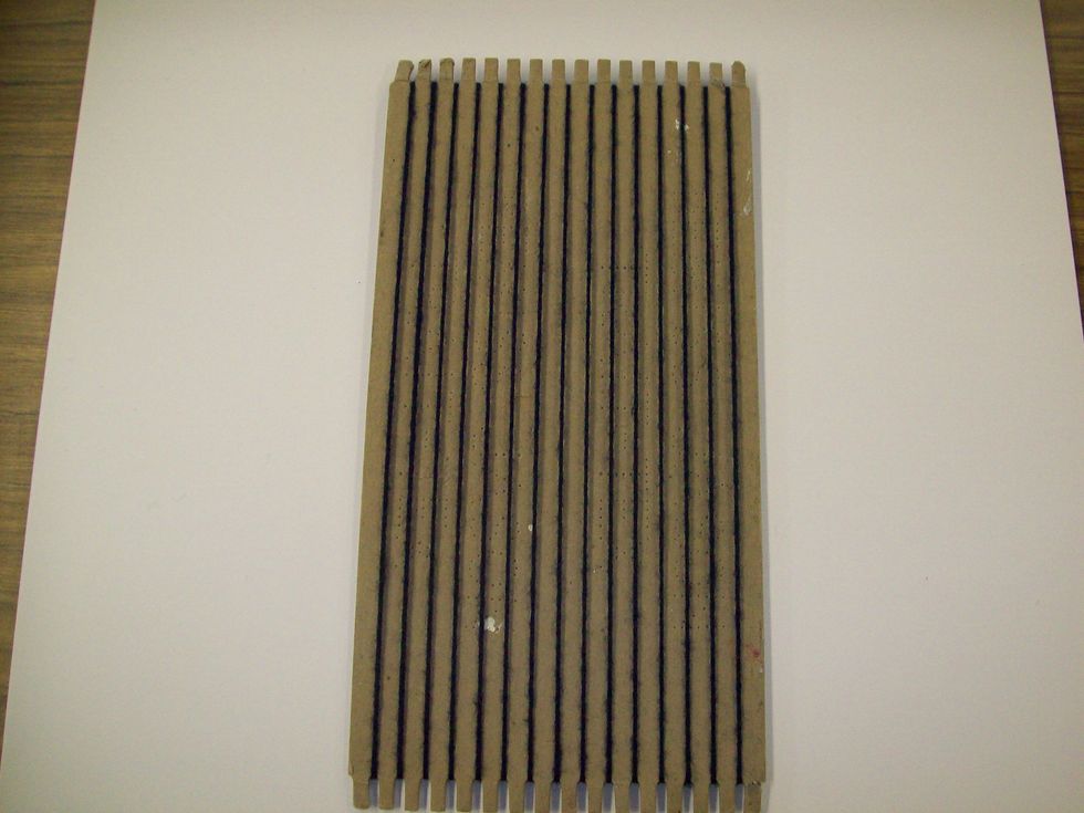 This is the front of the loom. The vertical strings (warp) should be tight.