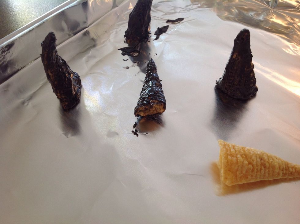 This is the messy bit: dip Bugles in chocolate (or finger paint it on). Allow to cool.