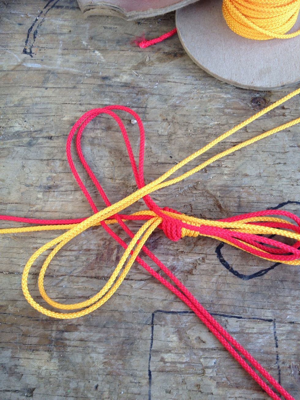 This is the most important step. Place the 2 opposite lines in the x across the middle so it makes 2 loops. On the back and front of each you should have a line just laying there.