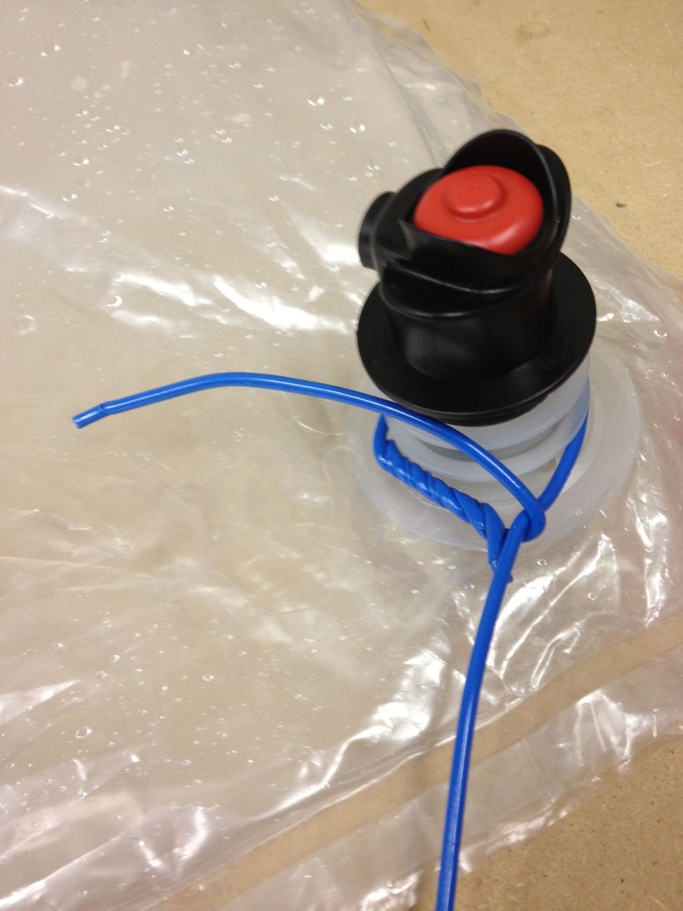 This is the toughest part, the first bend to lock the hanger in place on the fitting. Try and get it as tight as possible. Use the short end to wrap around the long end.