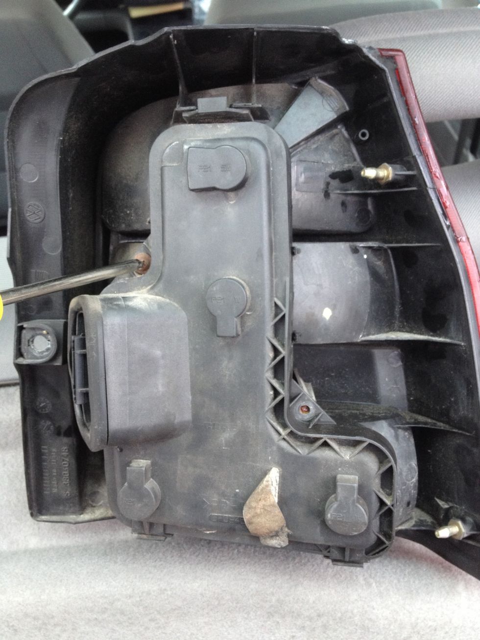 This is the unplugged light casing. There are two screws that need to be unscrewed. In this picture there is only one screw. On this casing you can also find the light bulb types.