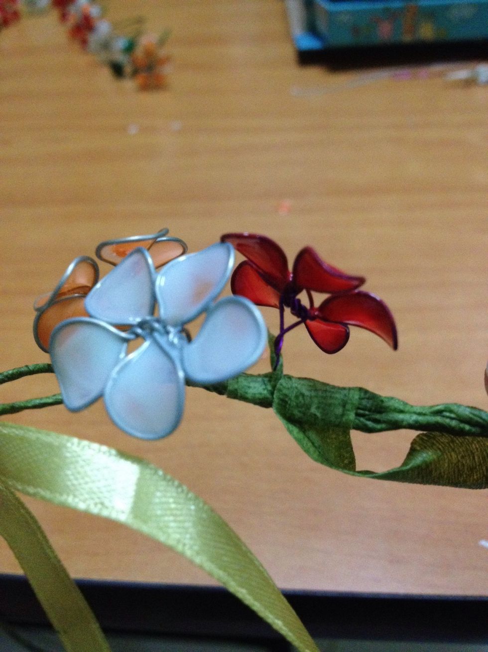 This is to adjust where the flowers would face later on as more will be added. Twist the stems of the flowers around the wreath before taping. Ensure the flowers are TIGHTLY bound to the wreath.