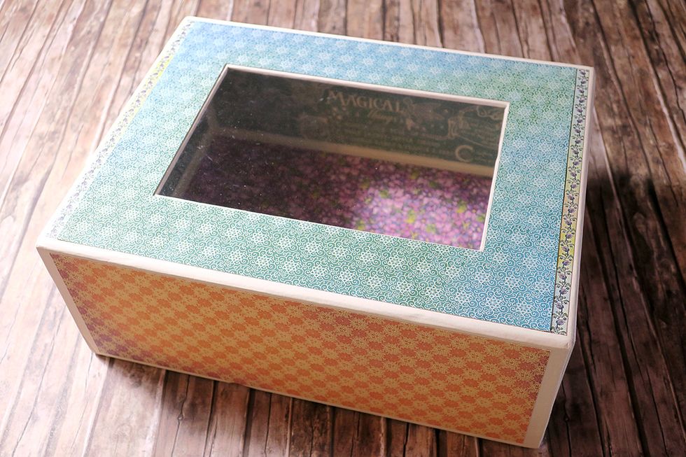 This is what you should get so far. You can add thin strips of designer paper to the left and the right side of the lid, if you feel like the window frame is too small.