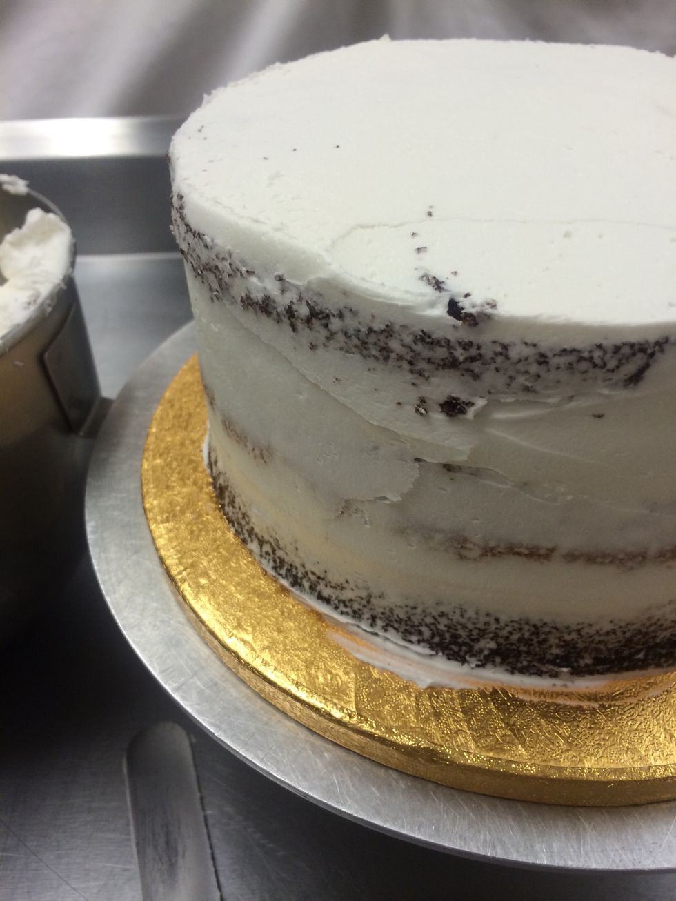 This layer of the frosting is very thin and it's ok to see the cake through the frosting. This is is just the crumb coat, we are going to refrost the cake and then cover it with rolled fondant.
