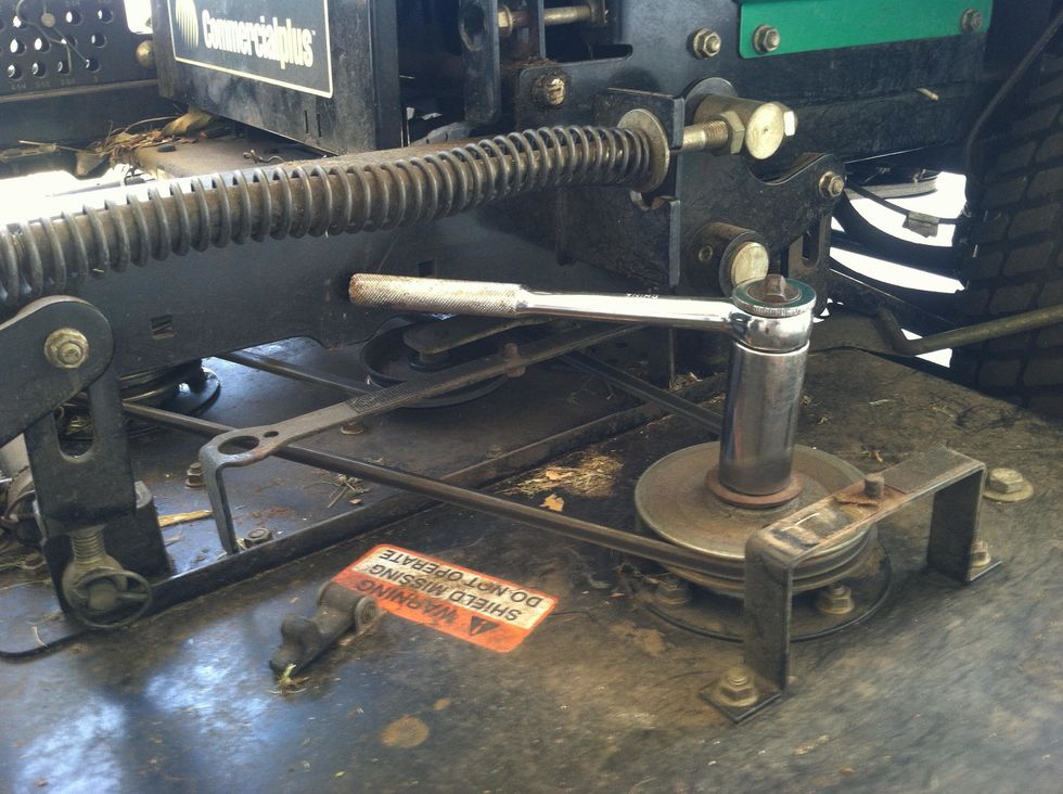 This mower has spindles that have a bolt through them with the blade held on the bottom of the bolt, to remove, you must have the top of the bolt held stationary