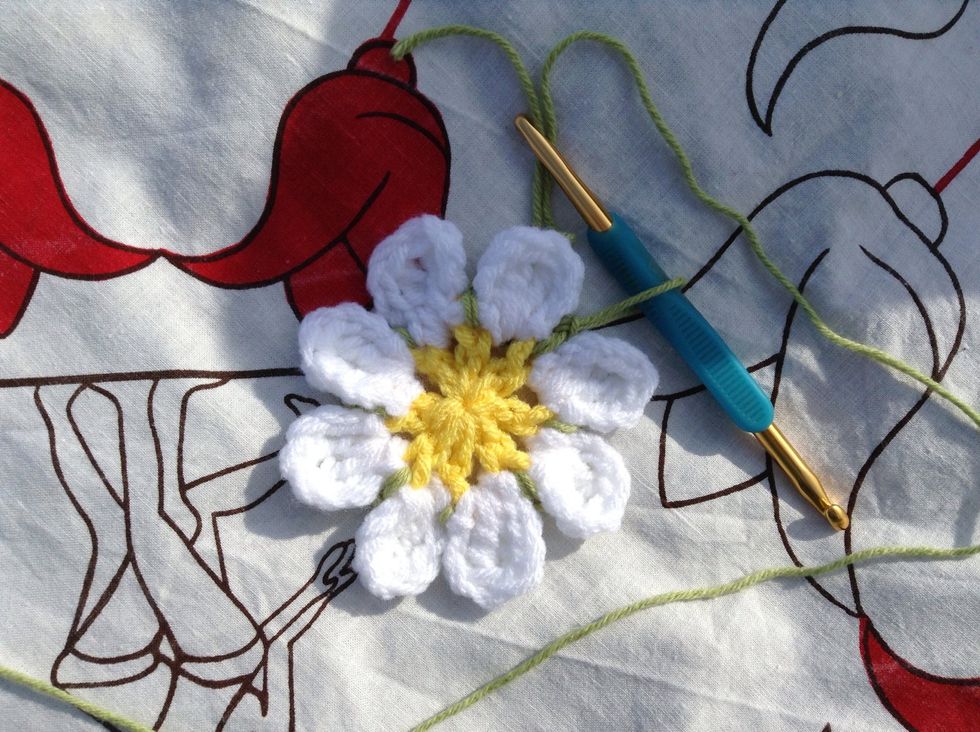 This next row will be worked into the green st at the back of the flower. Just fold the petals down and out of your way when you're crocheting around it.