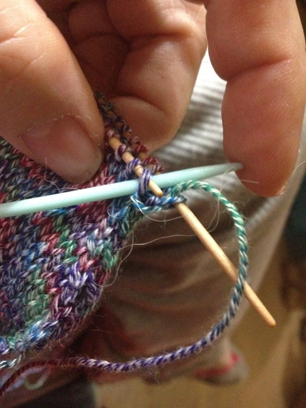 This photo shows the next step. Here you are going knitwise -- as if you would knit the stitch -- through the 1st stitch on the front needle. Now you can let that 1st stitch slip off the front needle.