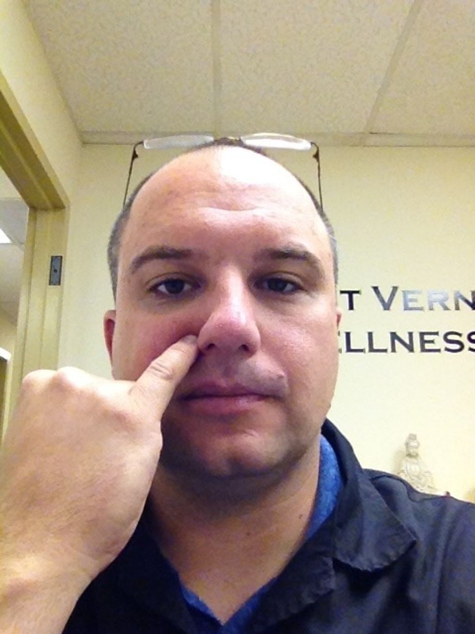 This point is located alongside of the nose. You can follow the crease (laugh line) up from the corner of the lip. There should be a depression that you can push into.