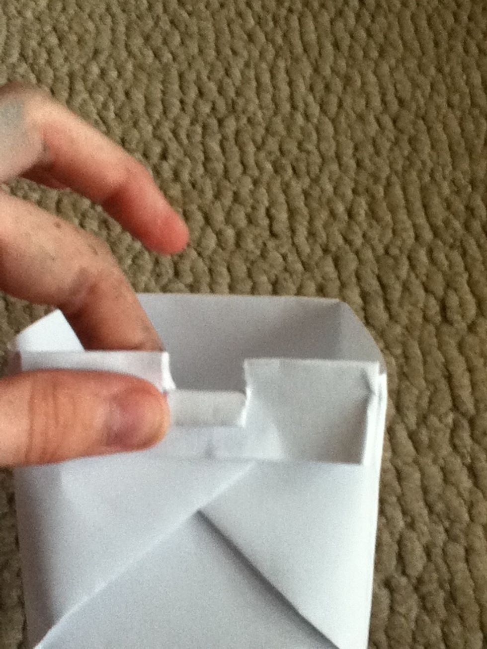 This step is optional. If you want to make your box more secure, rip two slits about an inch or less in the middle. Fold it down. It acts as a staple.