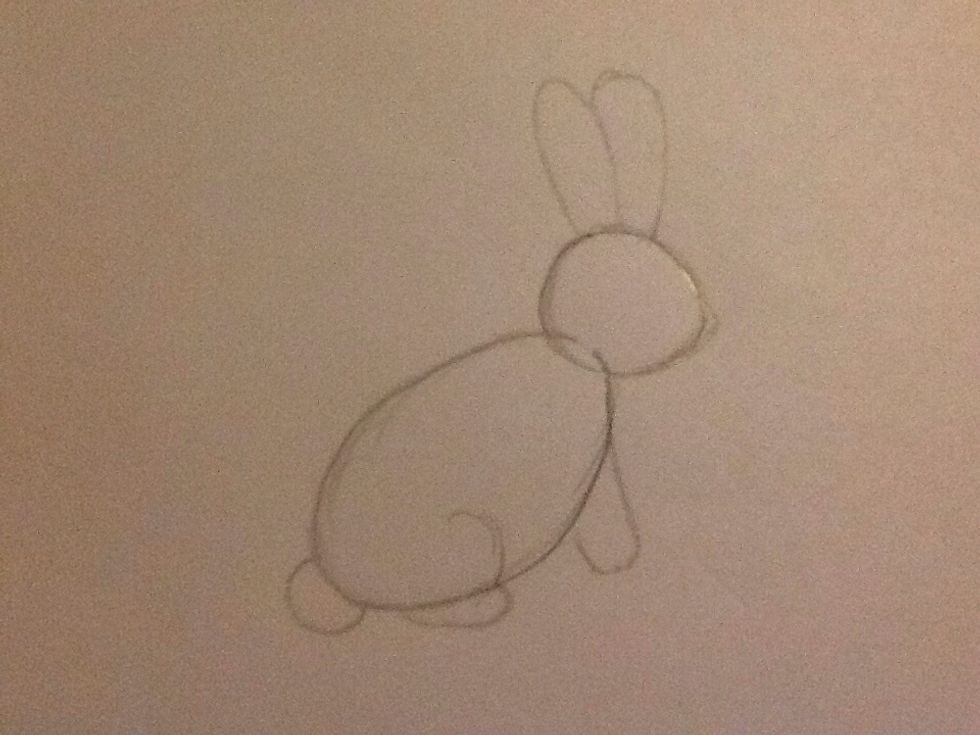 This step is where you draw the main shapes for the body. A point as a nose, two oval ears, a front leg which is a rounded rectangle, a small circle for tail and a back leg (semi circle and oval).