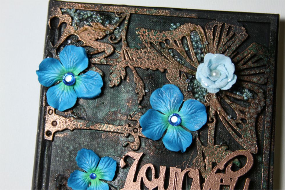 This step will require that you spray your book cover with your Colorations and heat emboss the chipboard.  As it heats up it absorbs the colors from the mists and embeds in the embossing powder.