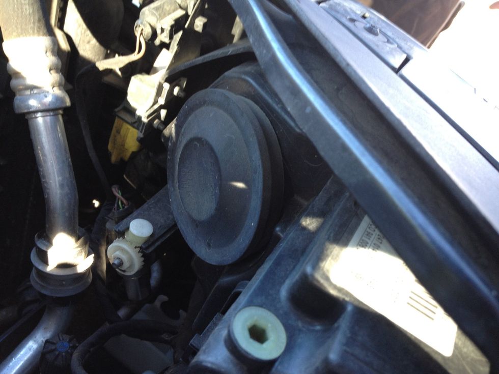 This time, the right front daytime running light or low beam is out. Pop the hood and locate the dust cover at the rear of the lamp assembly housing - remove it