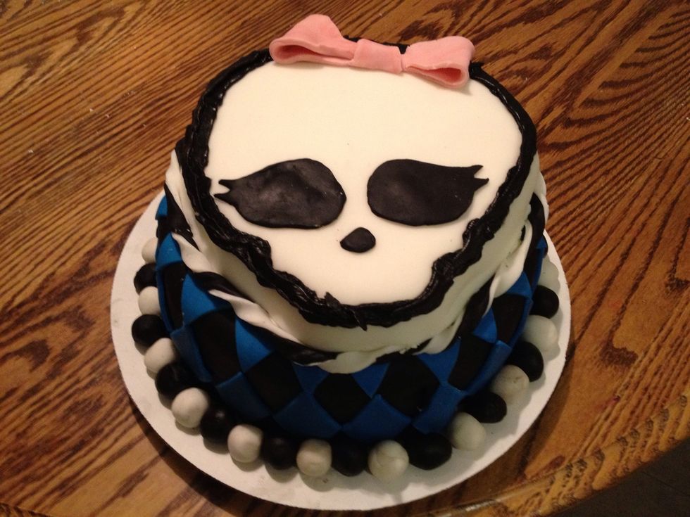 This was a trial run for my daughter's birthday next month. In hindsight, I would make the Skullette smaller, the fondant balls at the base smaller, and purchase some red fondant for the bow.