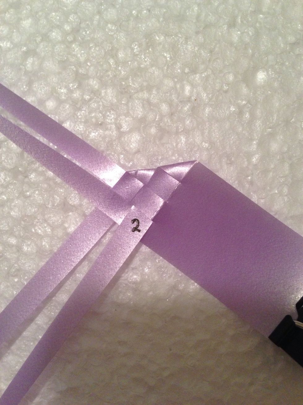 This will be the RIGHT wing.  Fold right 2 strips diagonally & interlace as shown.  Label 2 MUST interlace opposite of label 1 (folded strip is on top of non-folded strip).