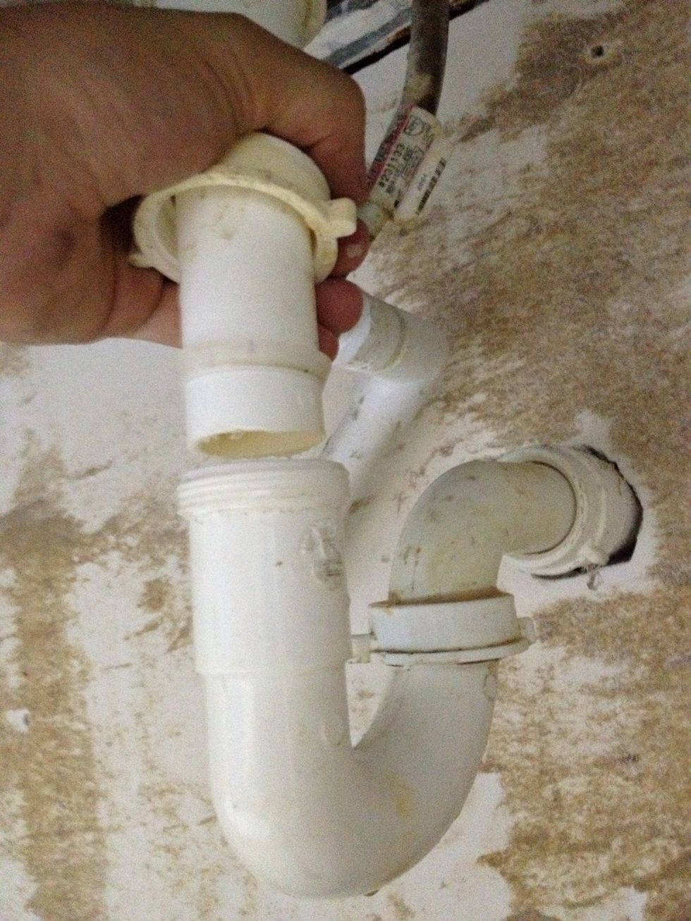 This will disconnect the straight PVC pipe from the top of the trap.