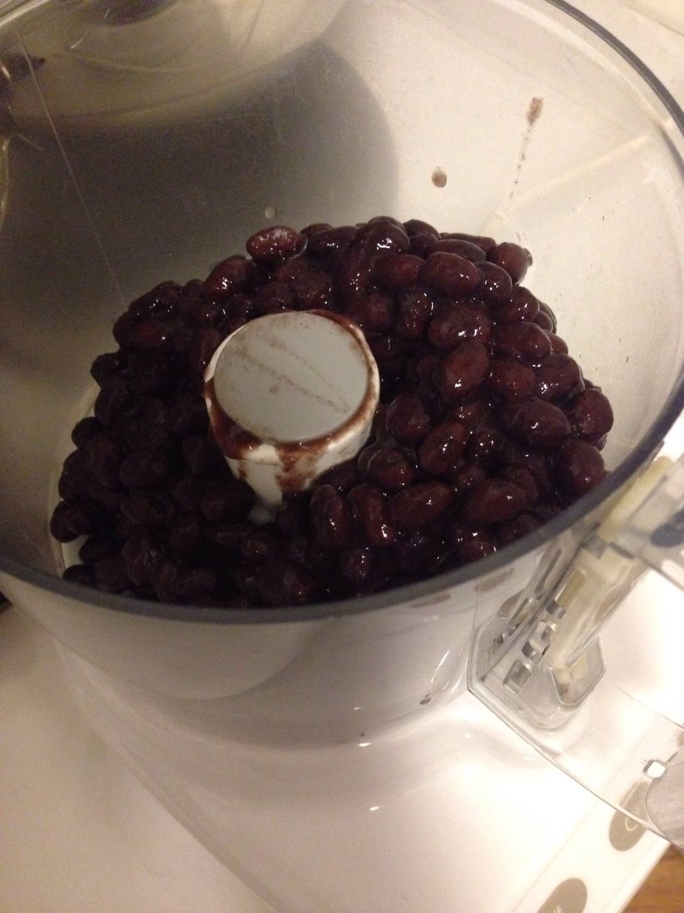 Thoroughly rinse and drain your black beans and add them to your food processor or blender.