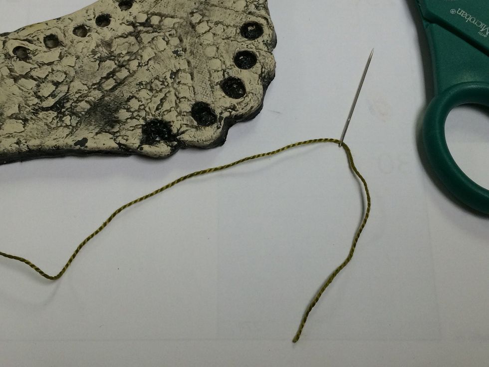 Thread about 3 inches of a long peice of thread throught the needle.