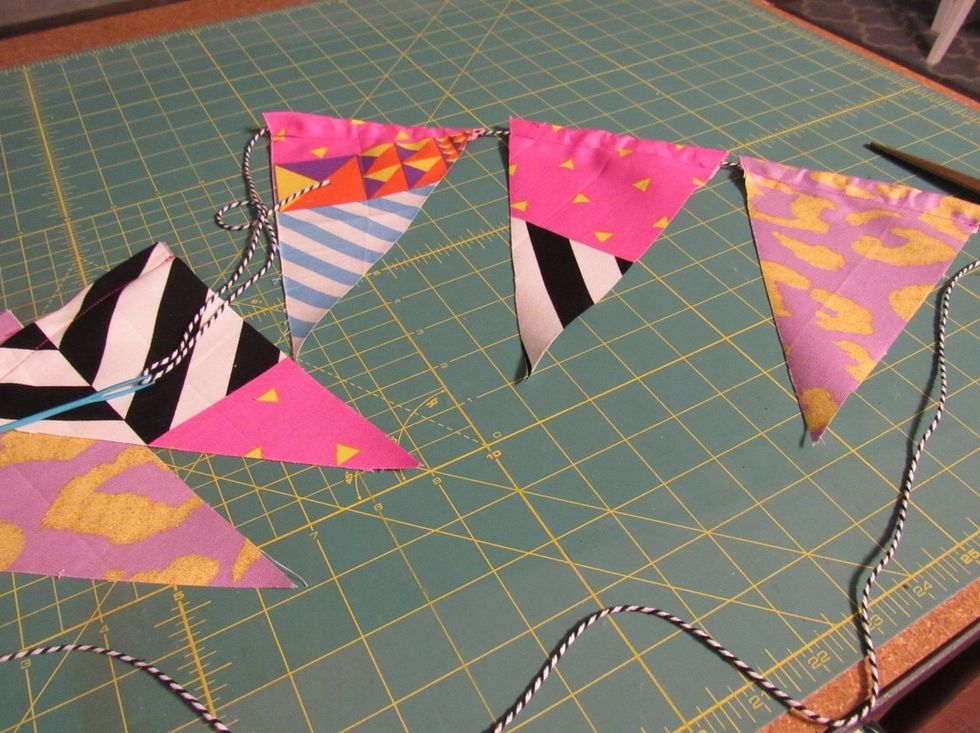 Thread baker\u2019s twine through the top of each pennant flag and space out to your liking.