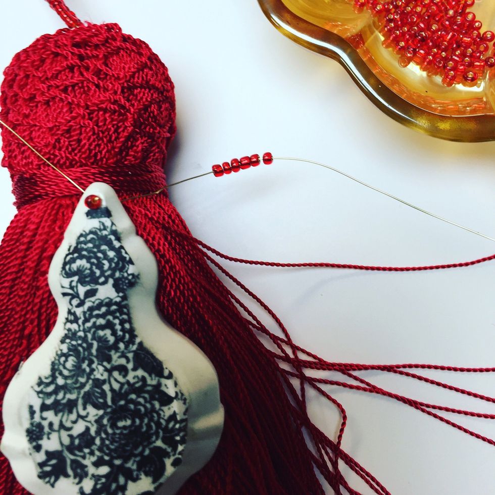 Thread more beads to secure your chandelier around your tassel
