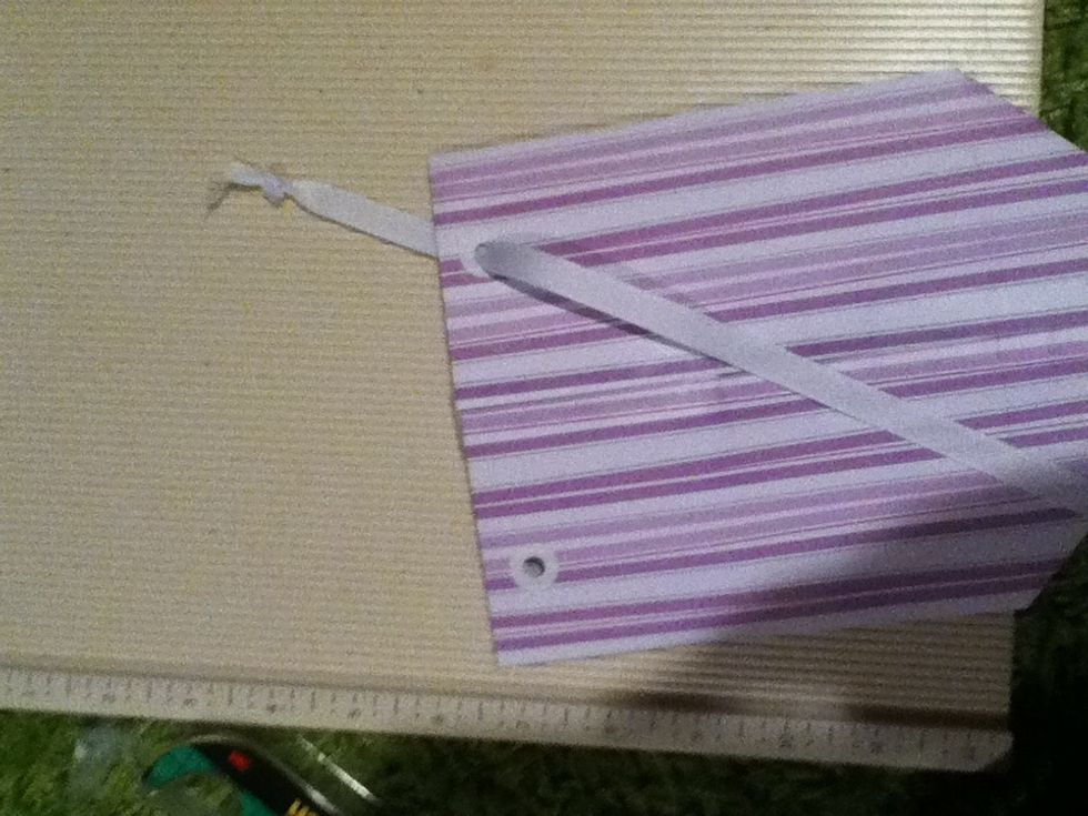 Thread one end of one piece through one hole, threading from the outside and ending on the inside. Tie a double knot at the end.