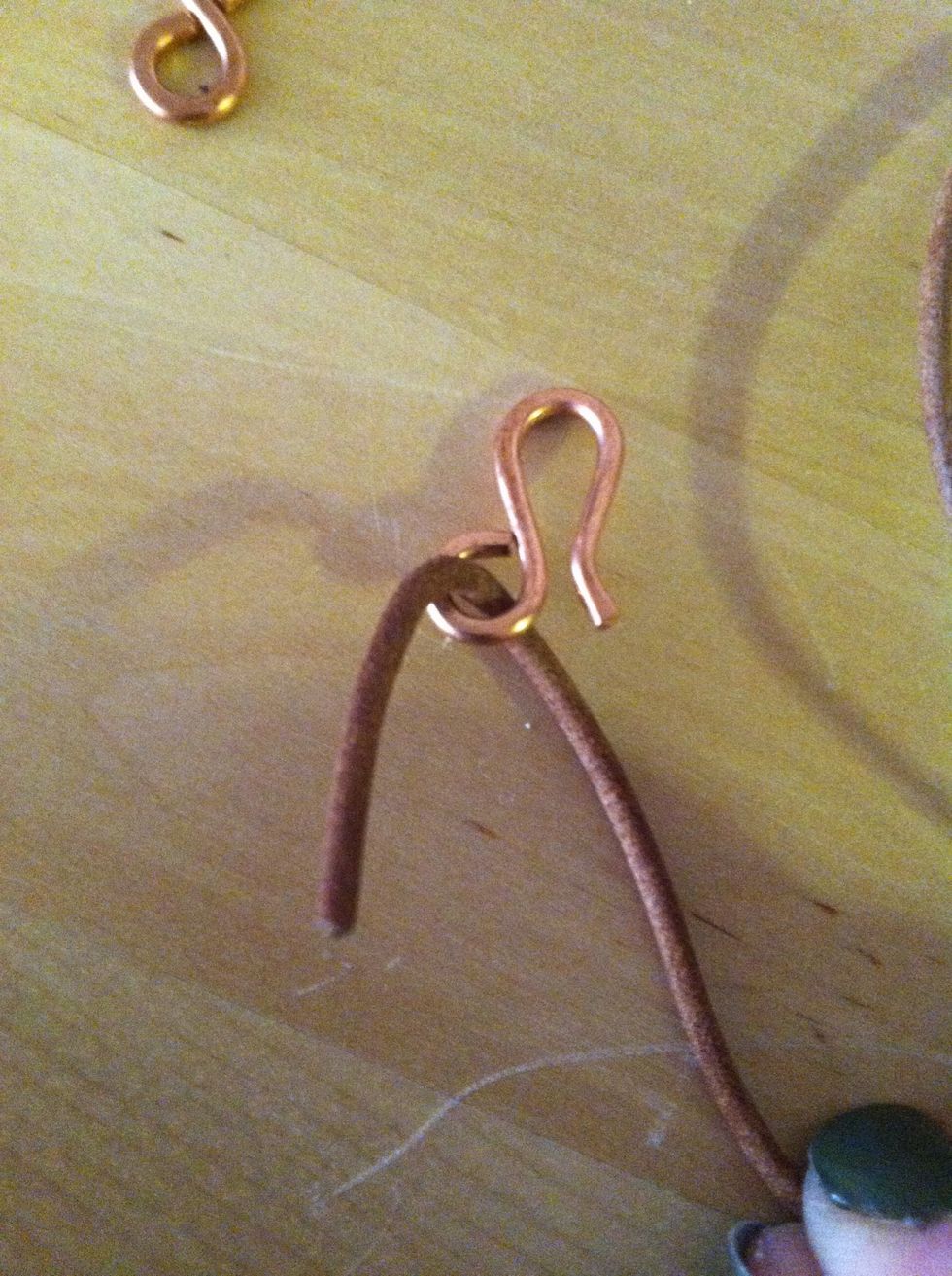 Thread one end of the cord through one end of the clasp. Bend leather so about 1/2" overlaps.